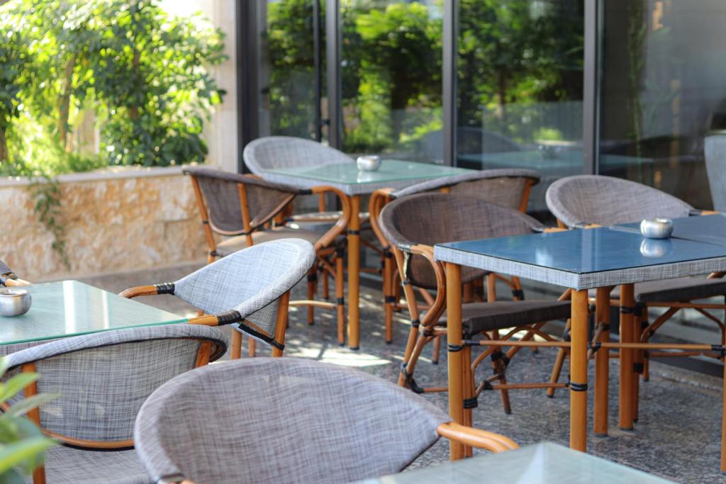 una fila de mesas y sillas en un patio en Rival Hotel Amman, en Amán