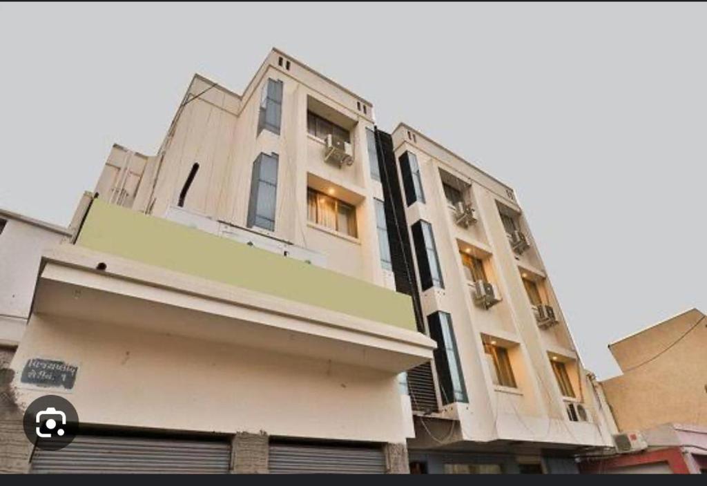 a tall white building with windows on the side of it at HOTEL SURYAKANT in Rajkot