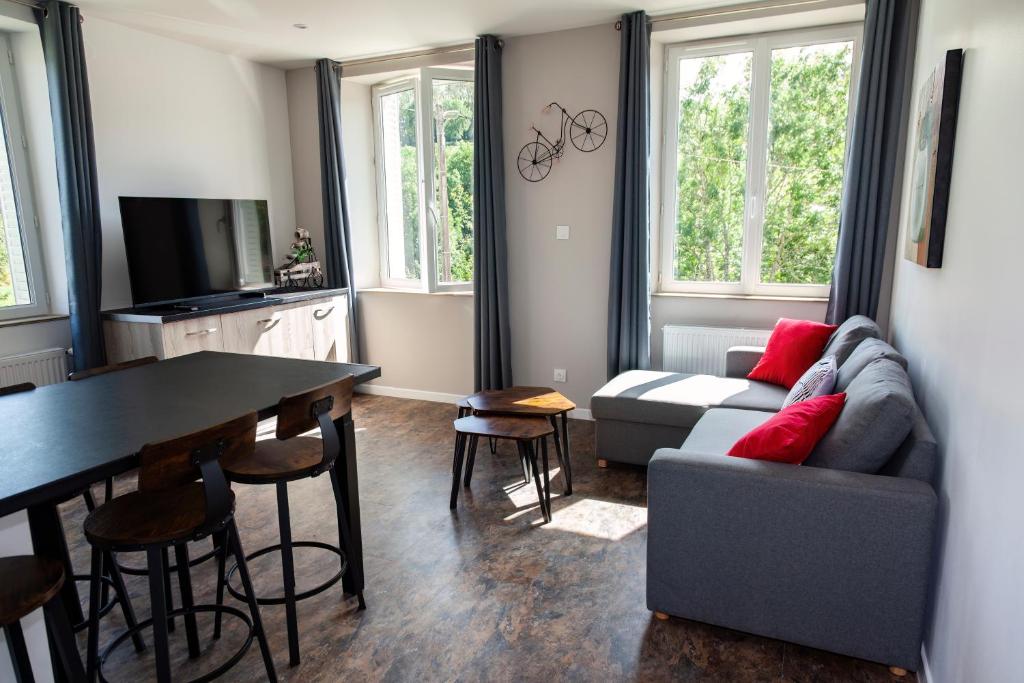 a living room with a couch and a table at LA BATISSE l'arbre beige in Le Grand-Abergement