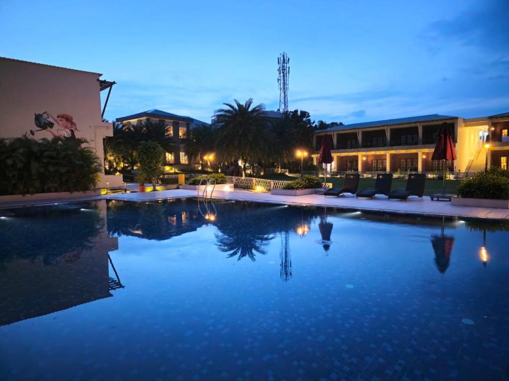 una piscina por la noche con luces en un complejo en The creek boutique resort & spa en Bolpur