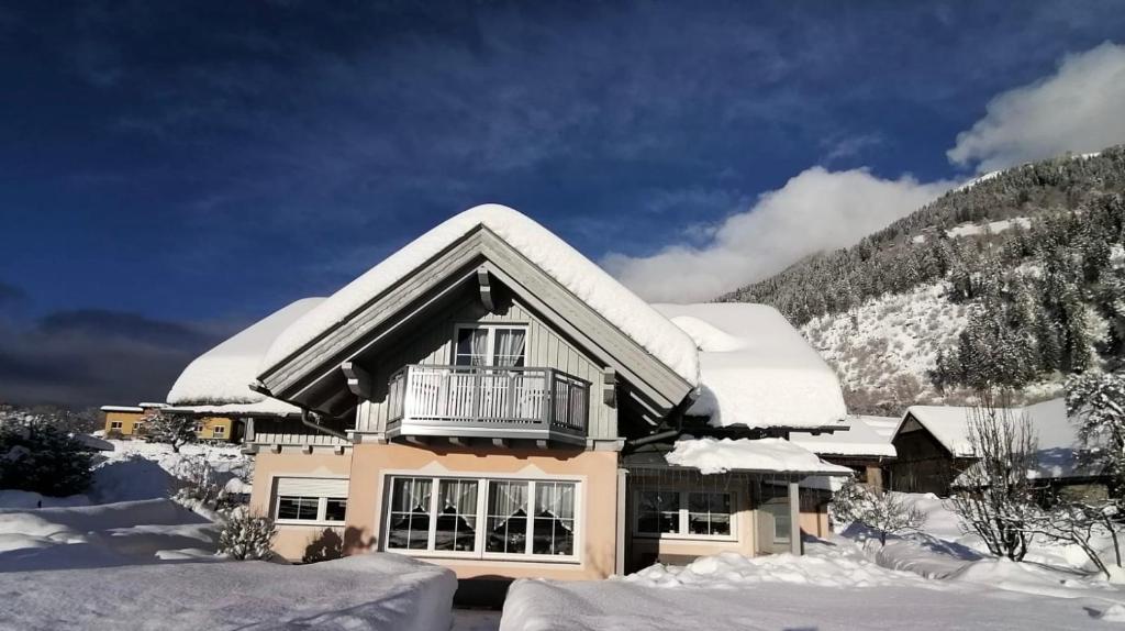 ein schneebedecktes Haus mit Balkon in der Unterkunft Ferienwohnung Daberer in Obervellach