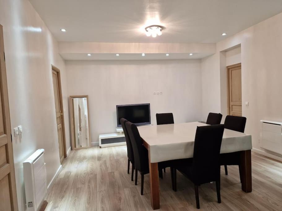 a dining room with a table and chairs and a television at L'Owen -10mn Genève-6 Pers-Cosy-Parking privé in Contamine-sur-Arve