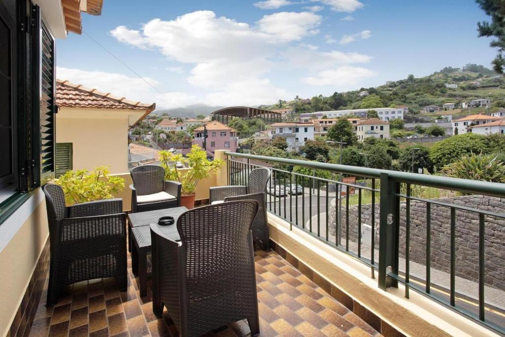 Un balcón con sillas y una mesa con vistas. en Casa do tio Inácio, en Santana