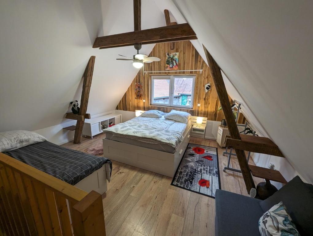 an attic bedroom with two beds and a staircase at Ferienhaus Lilla in Nürnberg