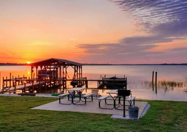 a dock with tables and chairs in front of a lake at Camp St. Cabanas Unit 3 on Lake Dora in Tavares