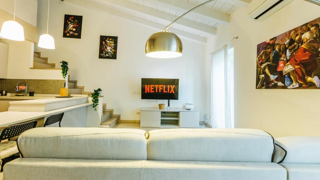 uma sala de estar com um sofá e uma televisão em Palazzo Romeo em Verona