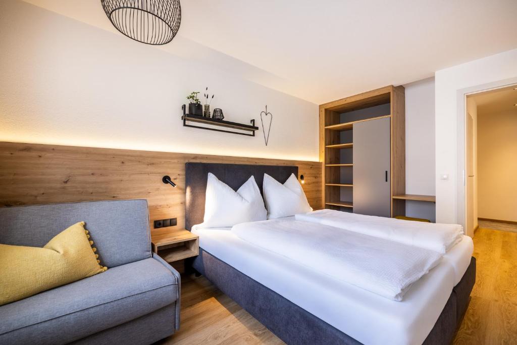 sypialnia z dużym łóżkiem i kanapą w obiekcie Appartements Evers w mieście Flachau