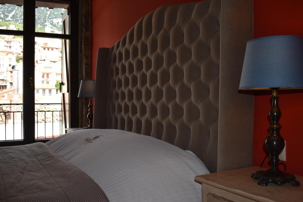 a bedroom with a bed with a headboard and a window at Alexandros Guesthouse in Arachova