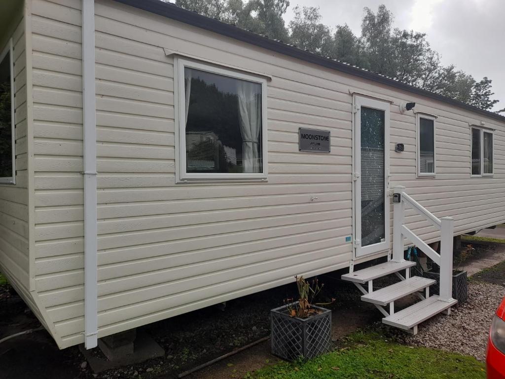 a white tiny house with a staircase on it at Arnies Place in Longridge