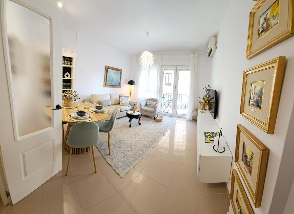 un soggiorno con tavolo e divano di Apartamento Vetalegua Jerez a Jerez de la Frontera