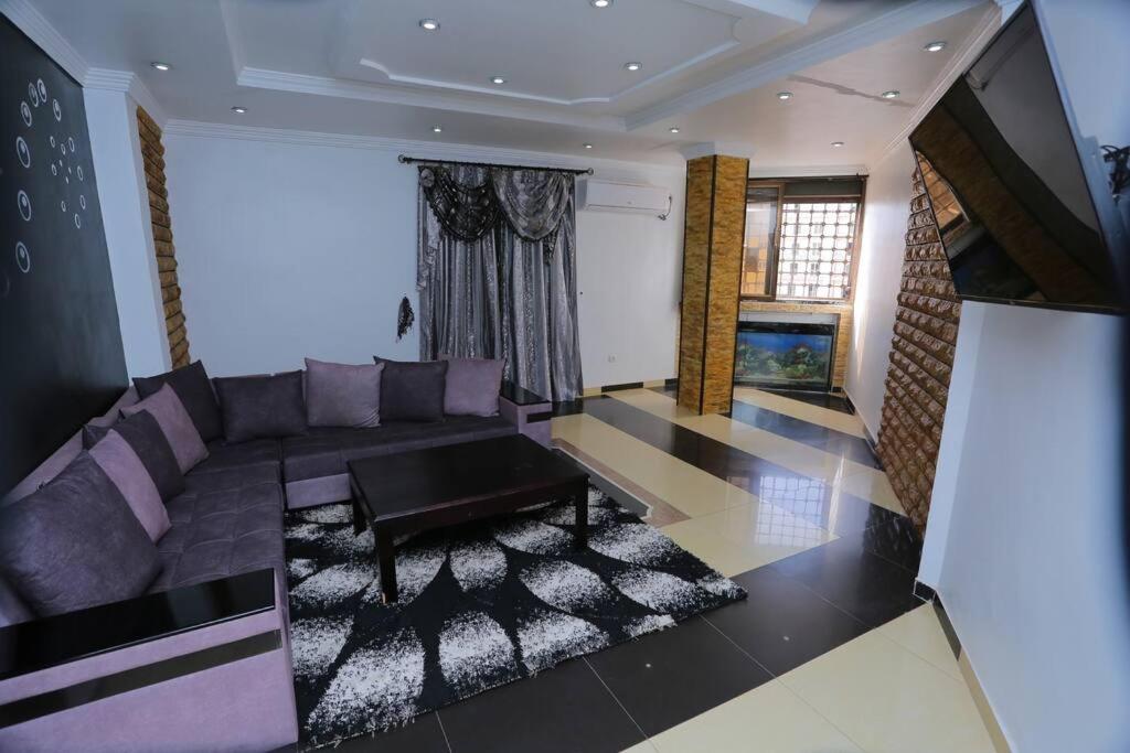 sala de estar con sofá púrpura y mesa en Appartement meublé Oran en Orán