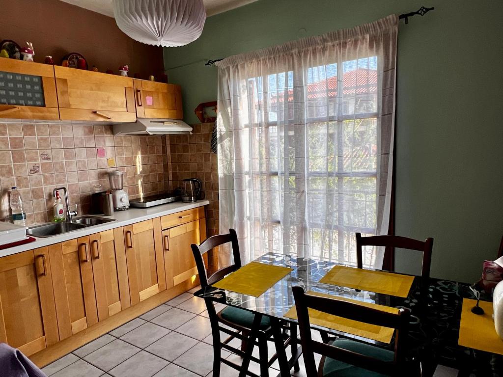 a kitchen with a table and chairs and a window at Sunny house at ancient Mycenae, close to Nafplio! in Mykines