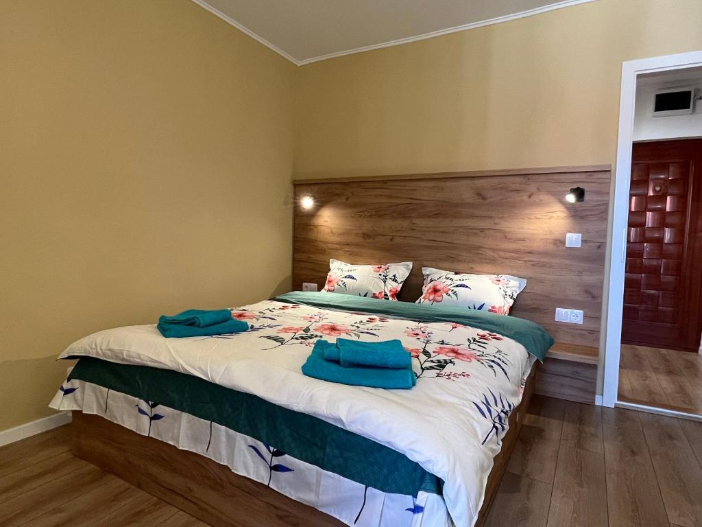 een slaapkamer met een bed met twee blauwe handdoeken erop bij Quiet flat with balcony, free parking included in Cluj-Napoca