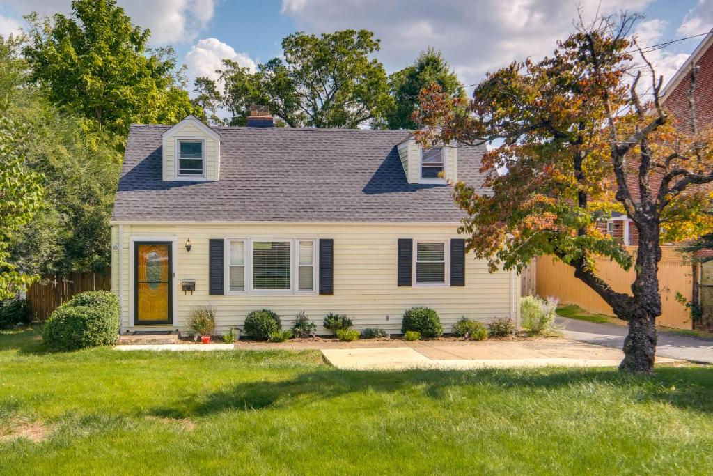una casa con una casa amarilla y un árbol en Pet-Friendly Falls Church Home with Fenced Backyard! en Falls Church