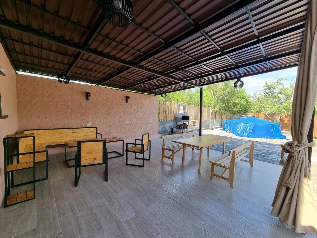 un patio cubierto con mesas, sillas y una parrilla en Cozy apartment with 5 bedrooms, whole apartment, апартмент целиком, en Dilijan