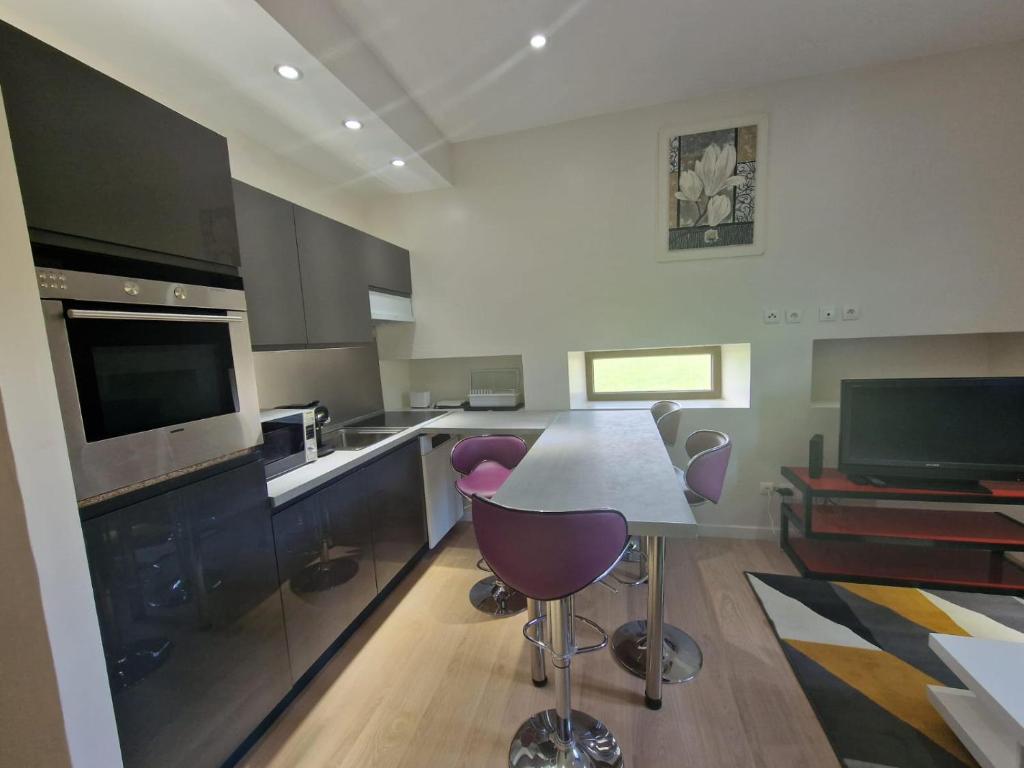 a kitchen with a table and some purple chairs at Le Keyla -10mn Genève-4 Pers-Cosy-Parking privé in Contamine-sur-Arve