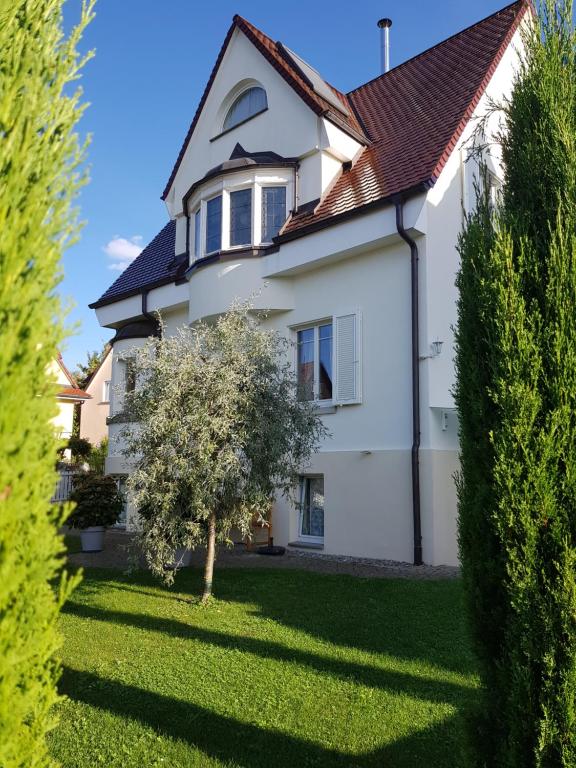 ein weißes Haus mit einem Baum im Hof in der Unterkunft Fewo Simone - Überlingen City - in Überlingen