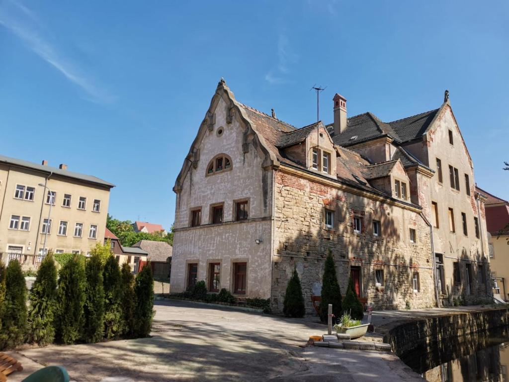 an old stone building in the middle of a street at Hotel Torino Zeitz in Zeitz