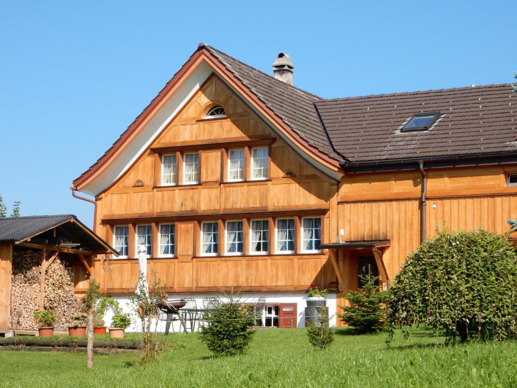 une grande maison en bois avec un toit en gambrel dans l'établissement Ferienhaus Rütiweid, à Appenzell