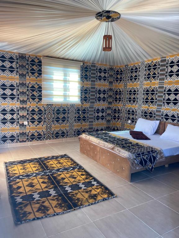 1 dormitorio con cama y alfombra en Wadi Rum Star Camp, en Wadi Rum