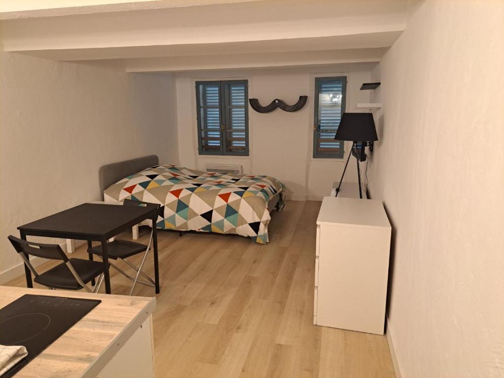 a bedroom with a bed and a table and a desk at 183 studio proche opéra in Toulon