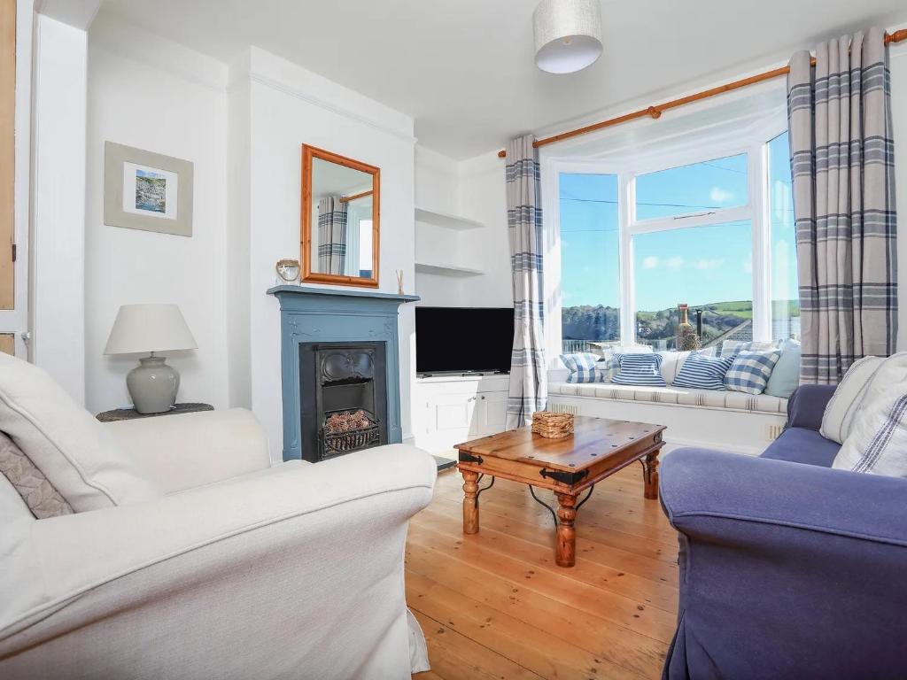 a living room with a couch and a fireplace at Dartmouth Cottage - River and Sea Views with Parking Permit in Dartmouth