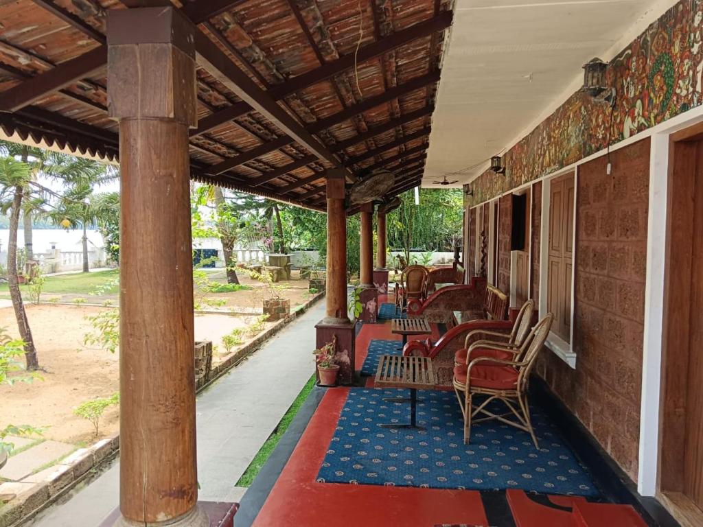 a porch with chairs and tables on a building at Ambadi's villa -Lake view resort in Pallipuram