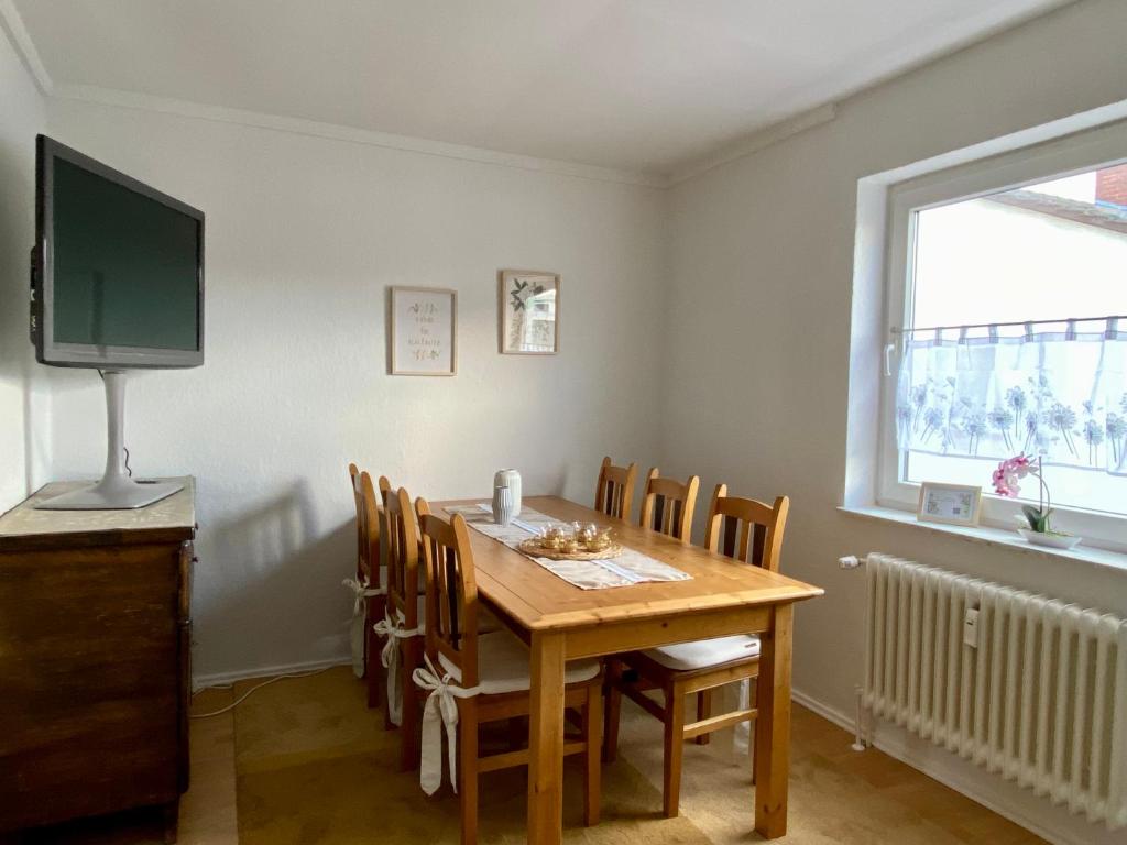 a dining room with a table and chairs and a television at Die 2eitwohnung in Hochheim am Main