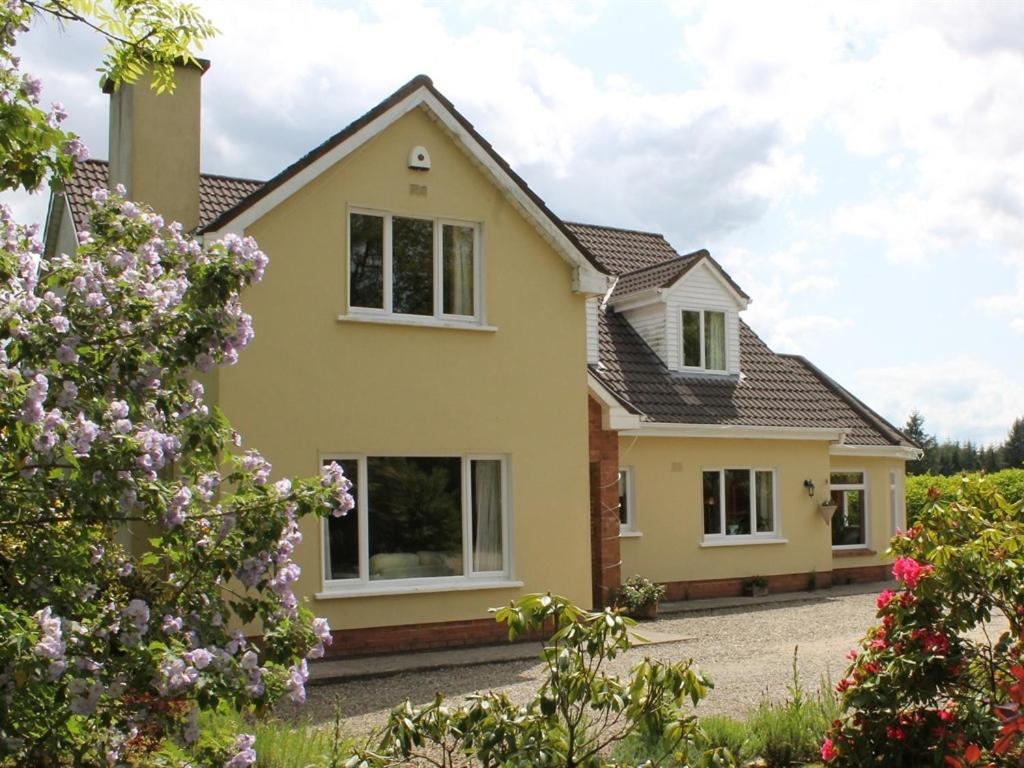 a yellow house with flowers in front of it at Blossom Hill Bed and Breakfast in Killaloe