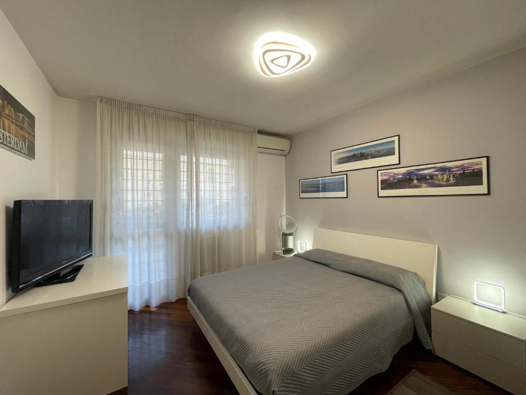 um quarto com uma cama e uma televisão de ecrã plano em Stanza Eur Tintoretto em Roma