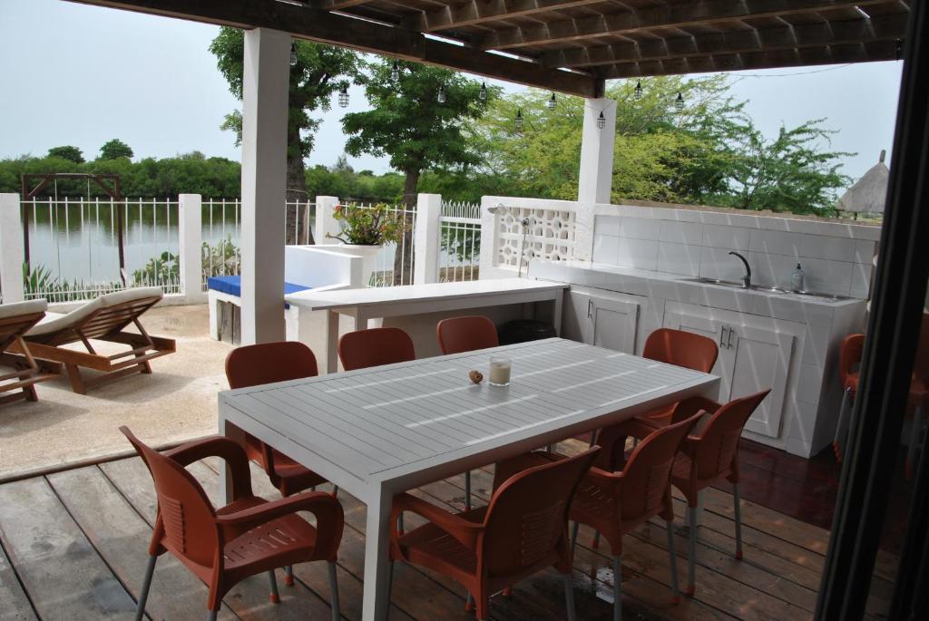 un patio con una mesa blanca y sillas en +221 Lagune Beach House, en Mbodiène