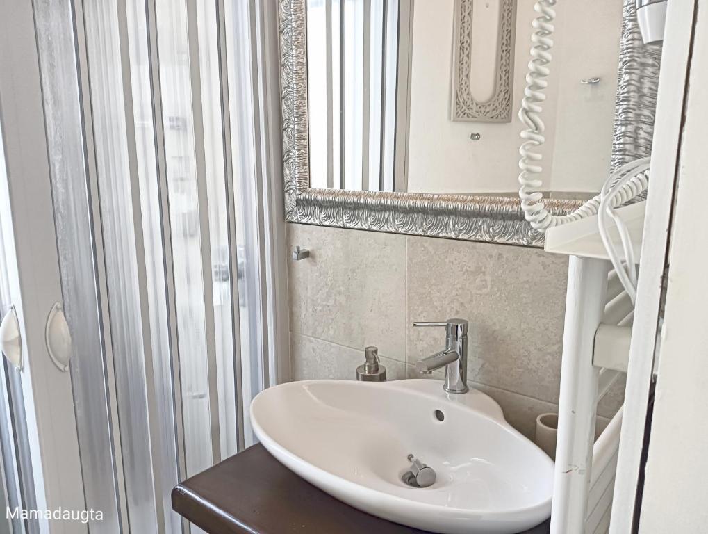bagno con lavandino e specchio di Kasakiwi Apartment a Vicenza