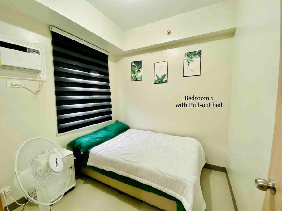 Habitación pequeña con cama y ventana en Newly Furnished 2BR -Condo in Cainta Rizal, en Manila