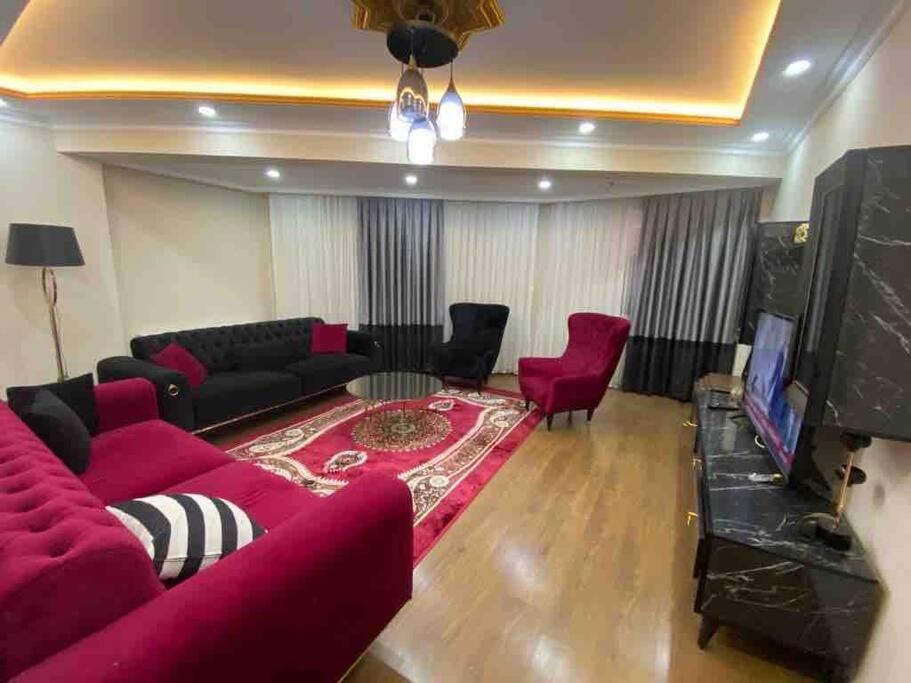 Duplex apartment next to airport في Arnavutköy: غرفة معيشة مع أريكة حمراء وتلفزيون