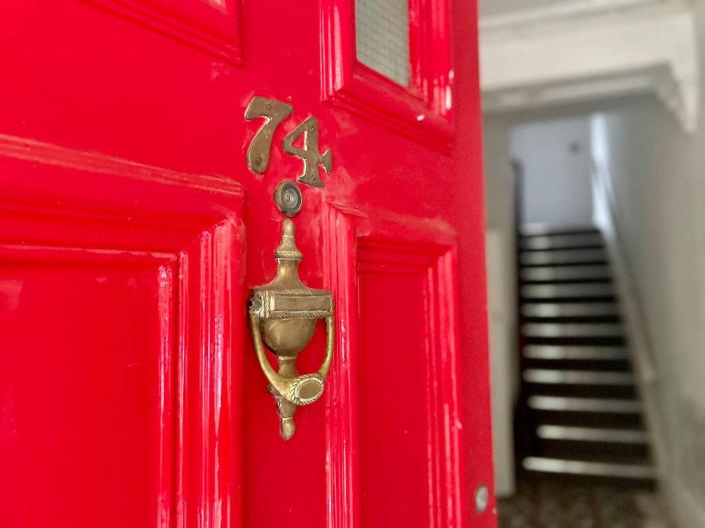a red door with a gold door knocker on it at Gloucester Serviced Apartments in Gloucester