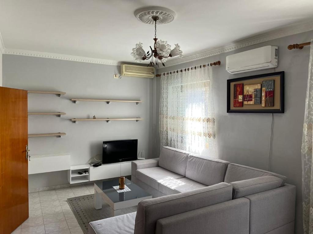 a living room with a couch and a tv at Dedi Apartment 2 in Shkodër