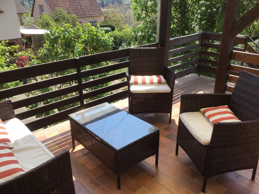 a patio with wicker chairs and tables on a deck at Maison individuelle dans les Vosges du nord in Niederbronn-les-Bains