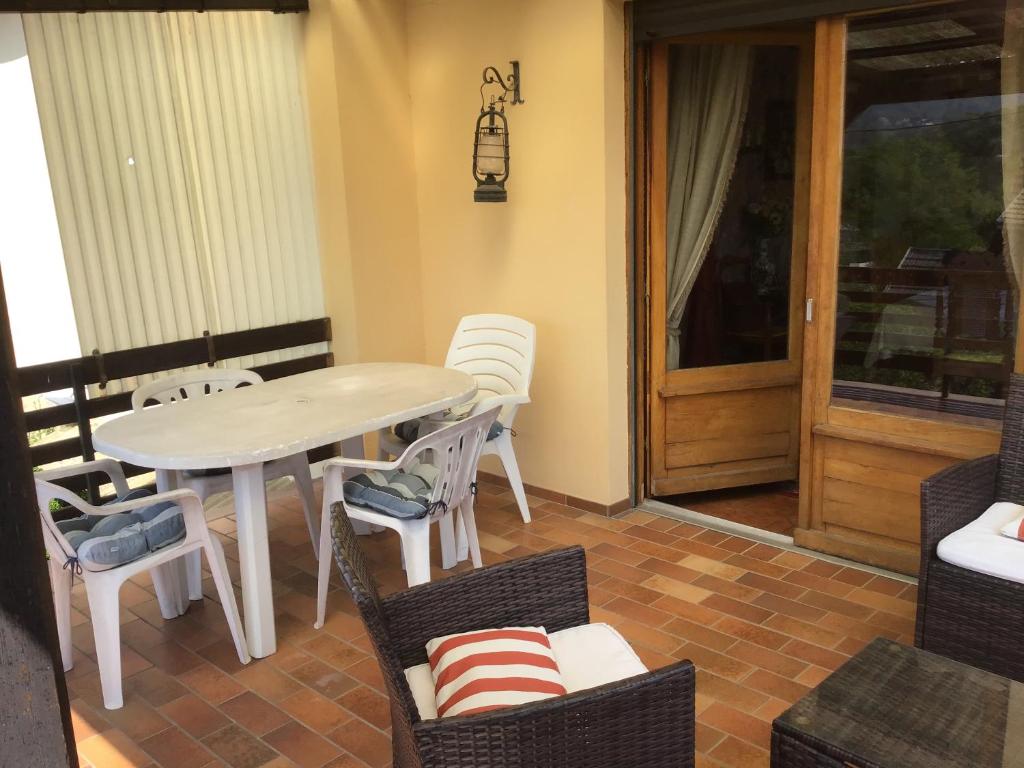 a table and chairs in a room with a patio at Maison individuelle dans les Vosges du nord in Niederbronn-les-Bains