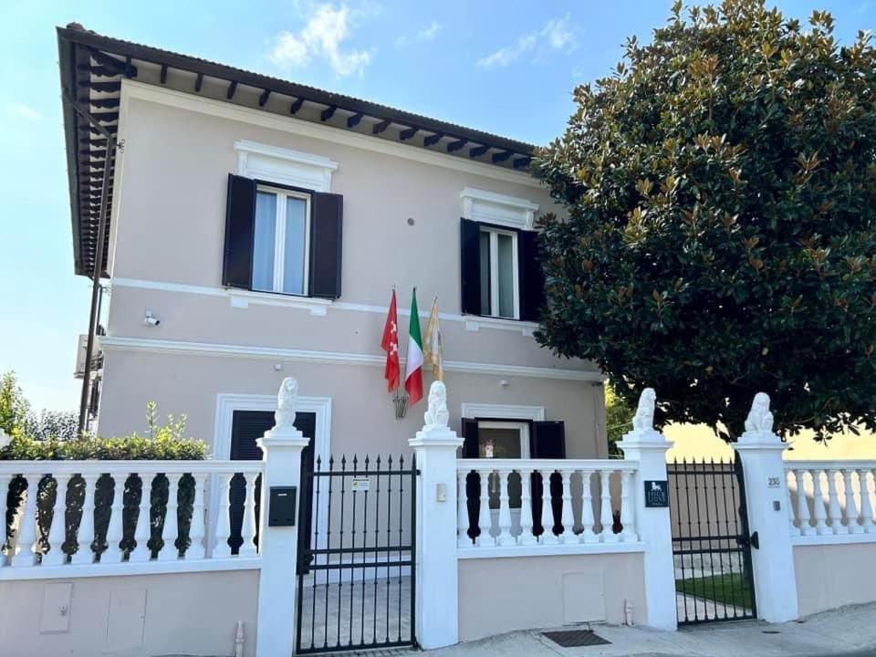 una cerca blanca frente a una casa blanca en FOUR LIONS VILLA GUESTHOUSE en Pisa