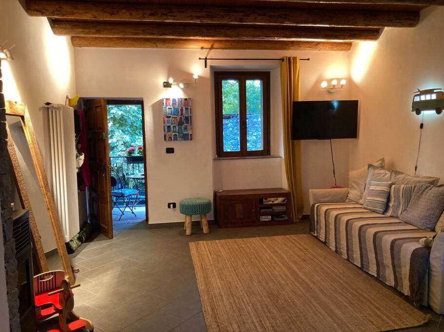 a living room with a couch and a television at Casa in pietra al lago di Como in Colico