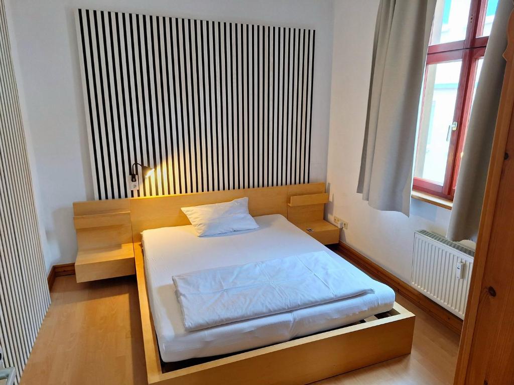 um pequeno quarto com uma cama num quarto em beliebtes City-Apartment Reutlingen em Reutlingen