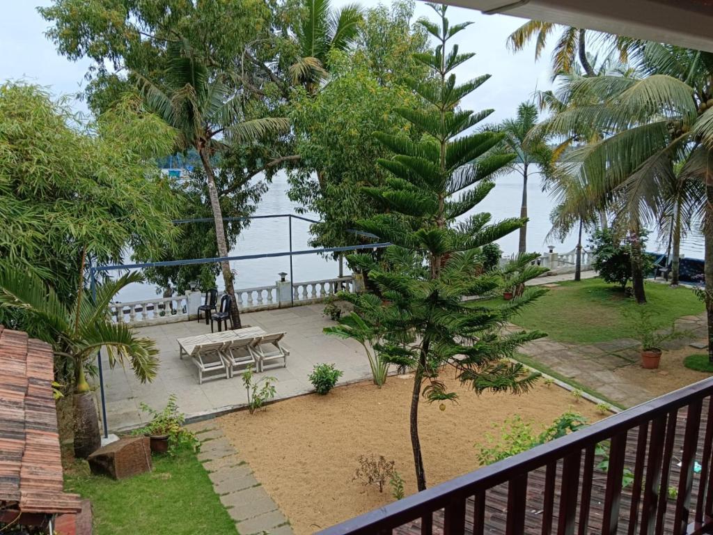a balcony with a picnic table and a view of the ocean at Ambadi's villa -Lake view resort in Pallipuram