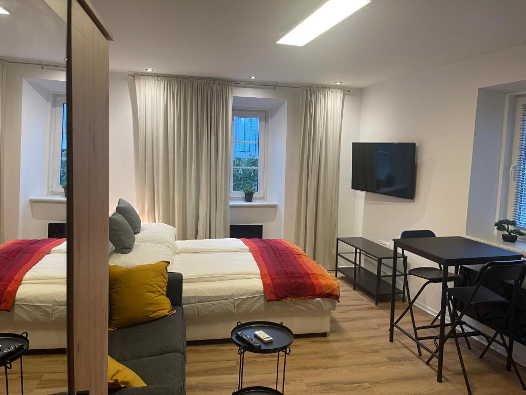 ツェリェにあるVilla Ariya Luxury Apartments & Spa Celjeのベッドルーム(ベッド1台、テーブル、テレビ付)