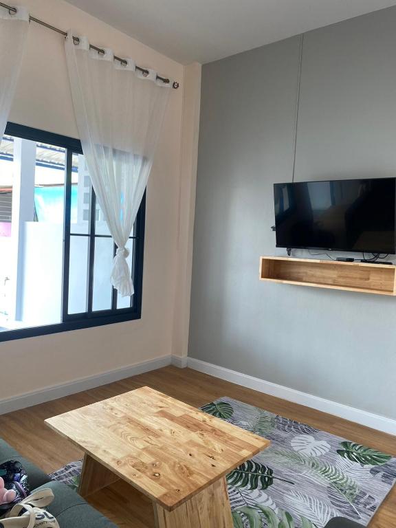 a living room with a table and a flat screen tv at COZY HOME @BETONG in Betong