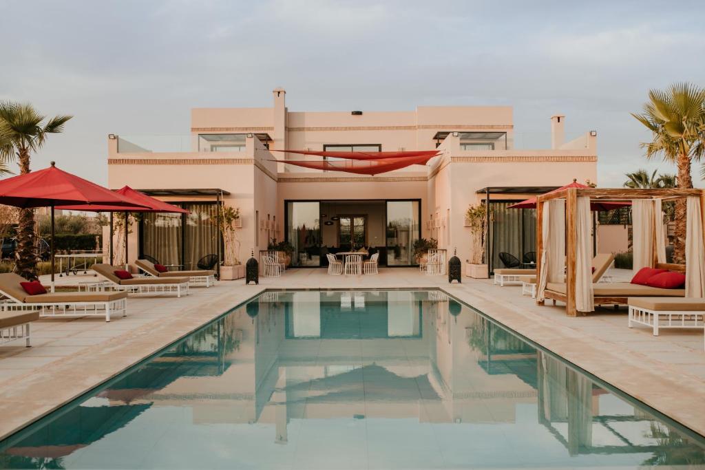 - une piscine avec des chaises et une maison dans l'établissement Villa Aljana Marrakech, à Marrakech