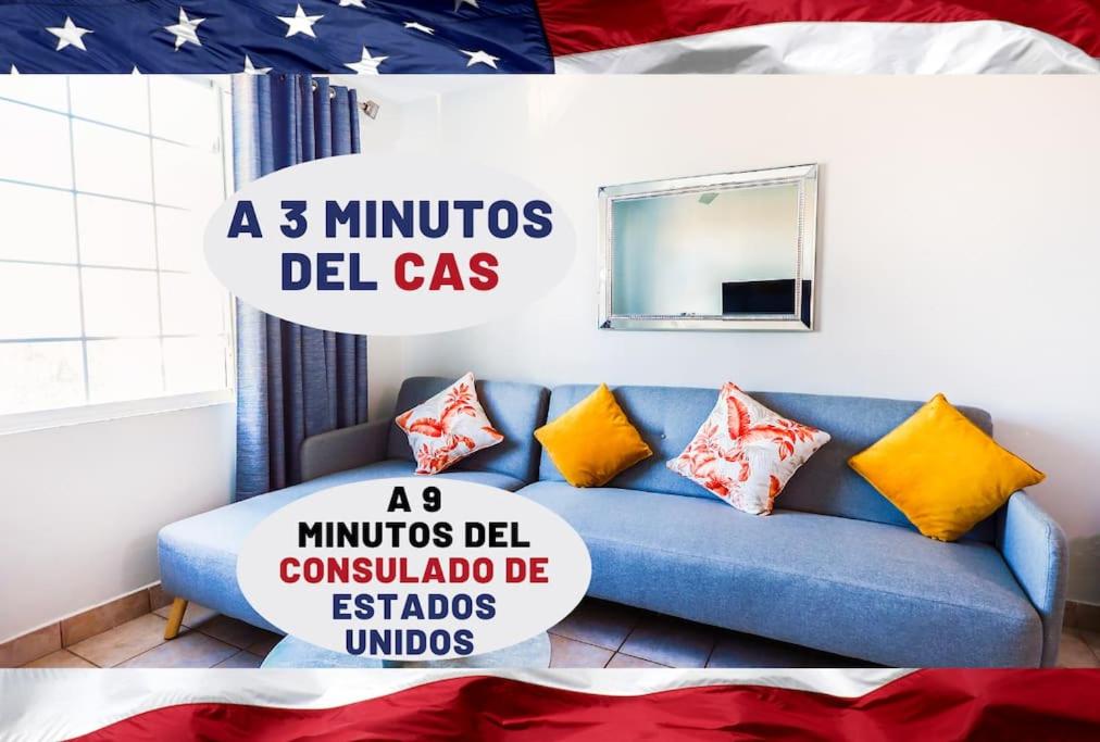 Depa - a 3 min del CAS VISA USA Consulado في Heroica Nogales: أريكة زرقاء في غرفة مع علم أمريكي