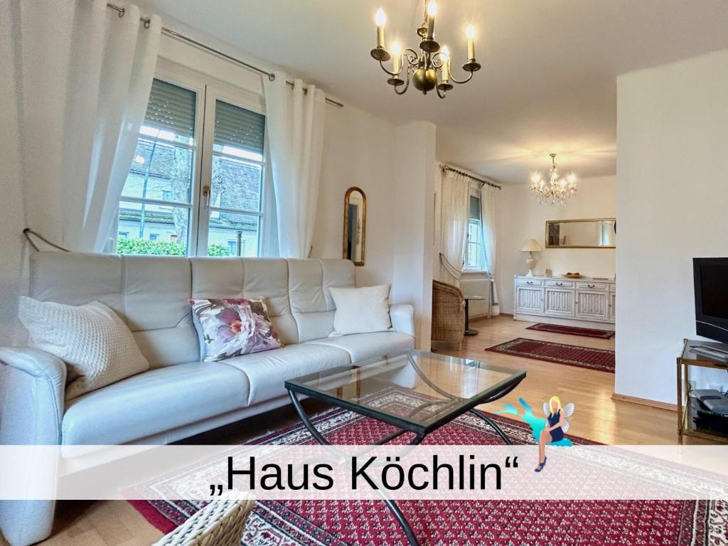 Ferienhaus Köchlin في لينداو: غرفة معيشة مع أريكة وطاولة زجاجية