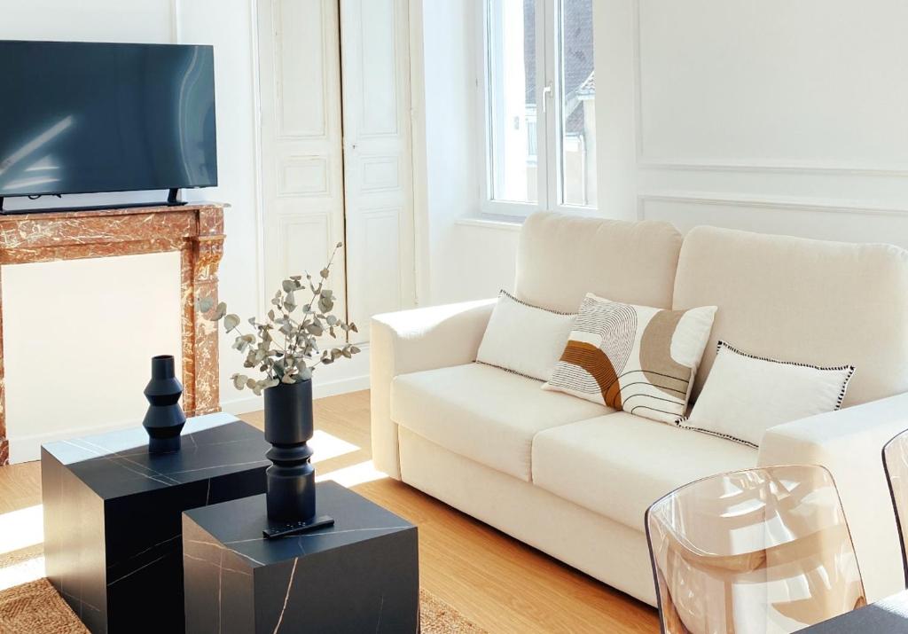 sala de estar con sofá blanco y chimenea en Le Haussmann ⸱ Stationnement gratuit ⸱ Fibre, en Déols