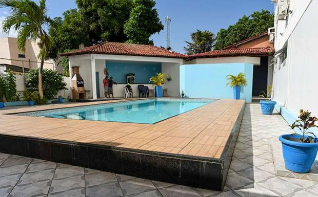 a swimming pool with a wooden deck next to a house at Barrudada Palace Hotel-Boa Vista in Boa Vista