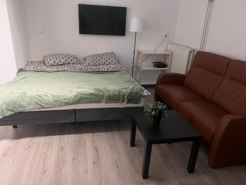 um quarto com uma cama e um sofá em Assad and Naveera, Steekkant 40 em Barendrecht